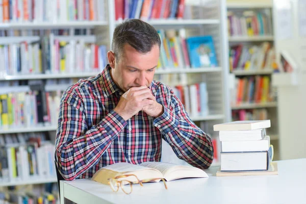 Leitor concentrado na biblioteca — Fotografia de Stock