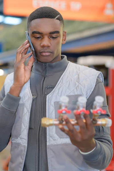 Ung rörmokare på telefonen i harware store — Stockfoto