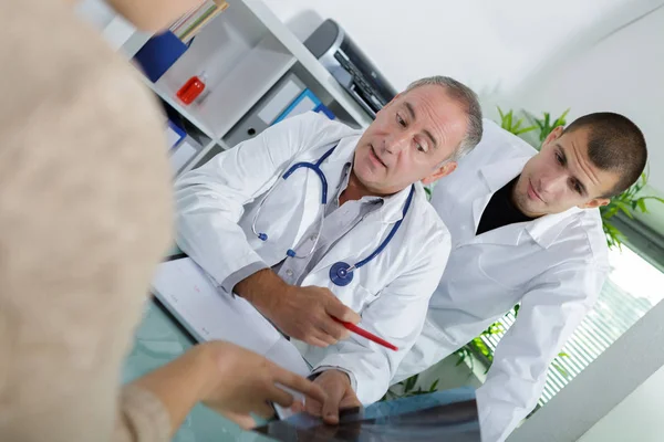 Médico sentado com paciente do sexo masculino na mesa — Fotografia de Stock