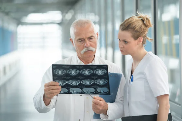 Senior Männlicher Radiologe Überprüft Röntgenbild Mit Kollegin — Stockfoto