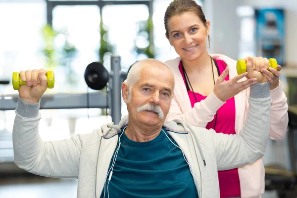 Elderly man lifting some dumbbells — Stock Photo, Image