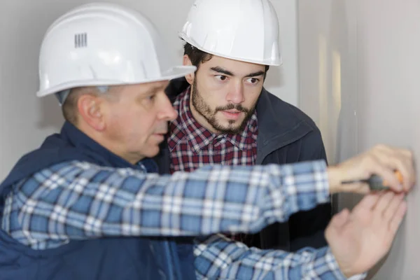 Two electricians sockets installingat house construction site — Stock Photo, Image