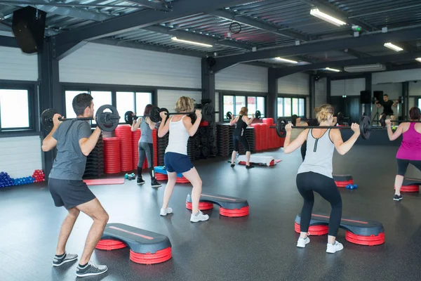 Les personnes qui s'entraînent avec des cloches dans un club de fitness — Photo