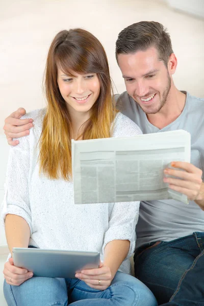 Casal feliz com as notícias no jornal — Fotografia de Stock