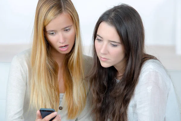 Dos adolescentes niñas impactados viendo mensaje en su teléfono inteligente —  Fotos de Stock