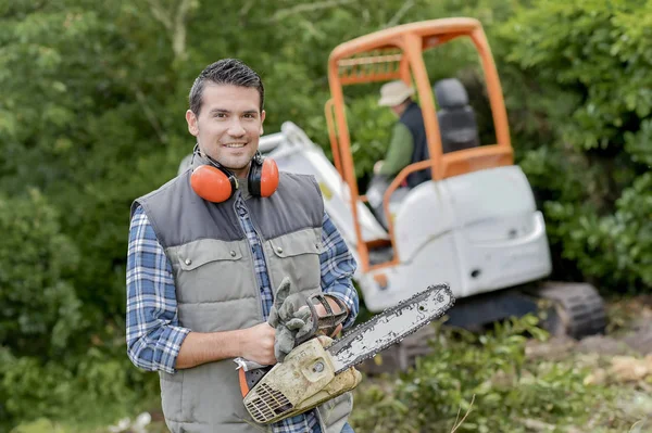 Tuinman met kettingzaag en bush — Stockfoto