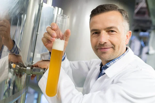 Brewer, ömlött a sör a sűrűségmérő henger sörgyár gyárban — Stock Fotó