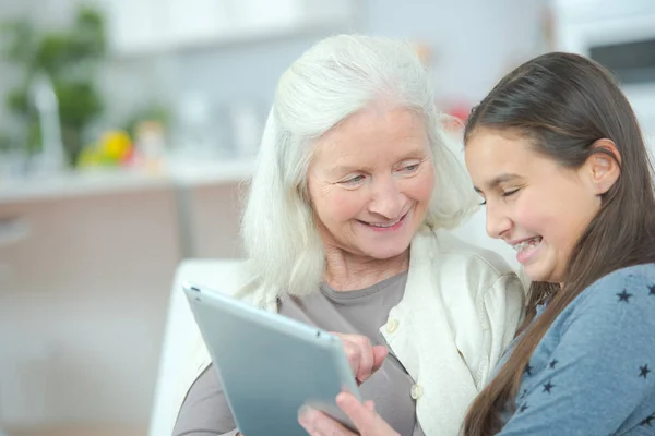 Mormor vid webbsurfning med grand dotter — Stockfoto