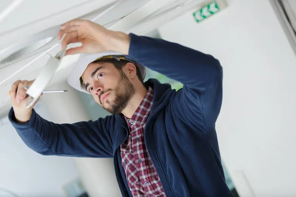 Mannelijke elektricien met schroevendraaier repareren brand sensor — Stockfoto