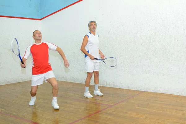 Dos hombres jugando tenis en el interior — Foto de Stock