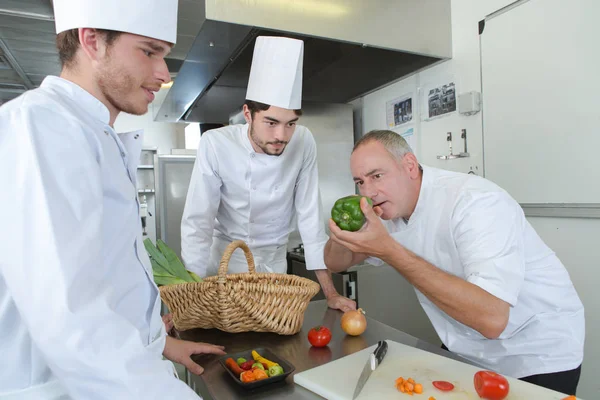 Metzger lehrt Lehrling, wie man Fleisch zubereitet — Stockfoto