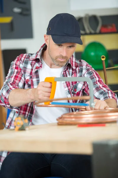 Arbeiter schneidet Kupferrohr — Stockfoto