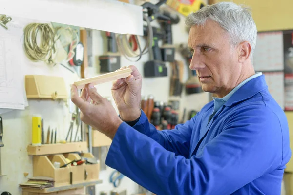 Portret van senior timmerman zitten in zijn atelier — Stockfoto