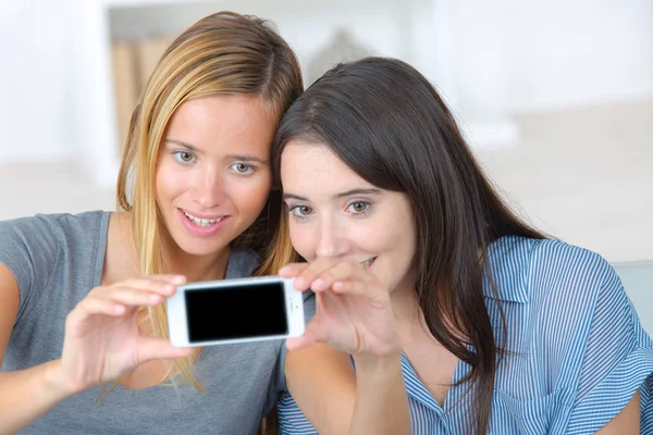 Dwóch młodych koleżanki, w pomieszczeniu biorąc selfie — Zdjęcie stockowe
