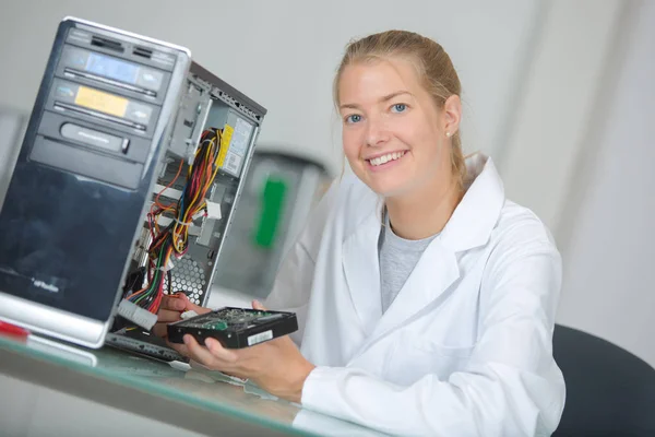 Jovem mulher sorridente técnico repara um computador — Fotografia de Stock