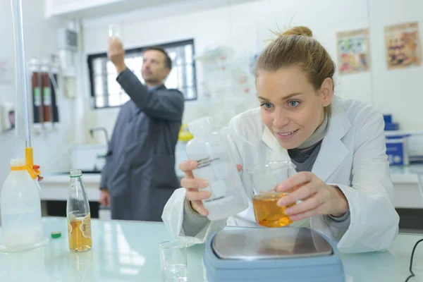 Assistente de laboratório analisando um líquido — Fotografia de Stock