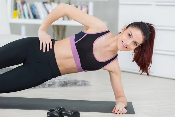 Brunette in plank position in the living room — Stock Photo, Image