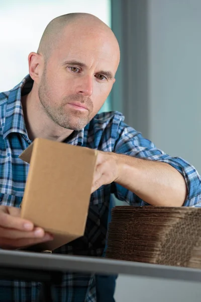 Mann faltet Karton in Verpackung — Stockfoto