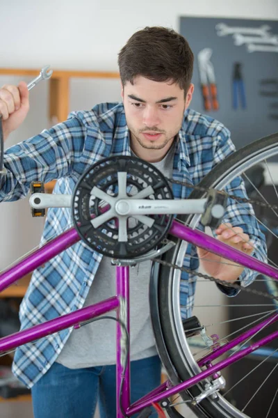 Хлопчик ремонтує велосипед — стокове фото