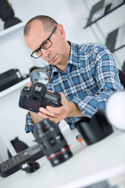 Reifer Mann repariert DSLR-Kamera in seiner Werkstatt — Stockfoto