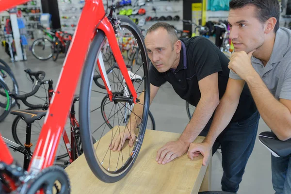 上げられたプラットホームに自転車を見ている二人の男 — ストック写真