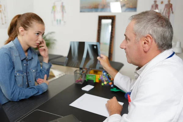 Médecin masculin et patient féminin discuter de rayons X — Photo