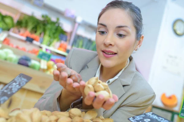 Consumer holding almonds and almonds — Stock Photo, Image