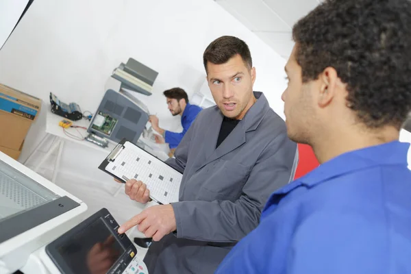 Joven reparador de fotocopiadoras con instructor experimentado — Foto de Stock