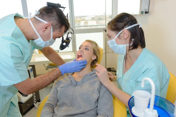 Dentista olhando para a boca do paciente — Fotografia de Stock