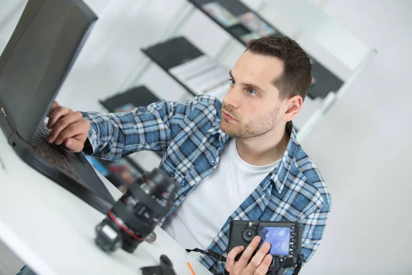 남자 카메라를 복구 하는 동안 노트북을 사용 하 여 — 스톡 사진