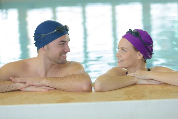 Couple dans la piscine avec bonnet de bain — Photo
