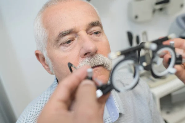 Doctor mostrando lentes especiales al paciente mayor —  Fotos de Stock