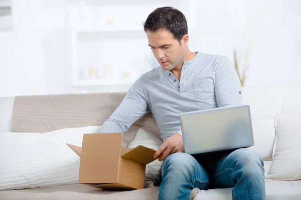 Entreprenör som öppna ett paket hemma — Stockfoto