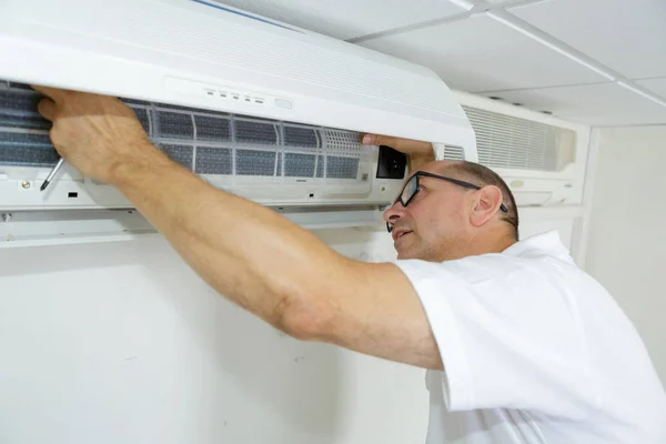 Reifer Techniker reinigt Klimaanlage — Stockfoto