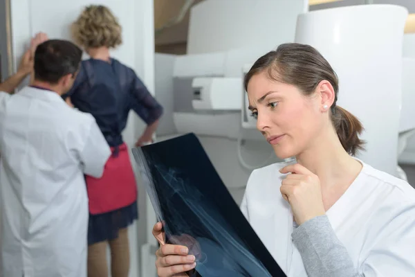 Ärztin überprüft Röntgenbild sehr besorgt — Stockfoto