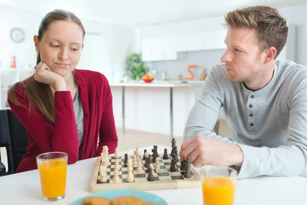 Pareja joven jugando al ajedrez en el interior del hogar — Foto de Stock
