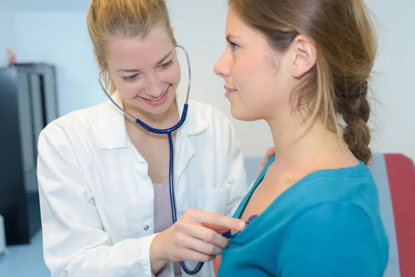 Medico femminile che controlla la frequenza cardiaca femminile del paziente — Foto Stock