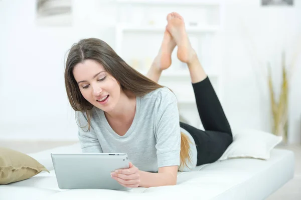 Vrouw op bed met tablet — Stockfoto