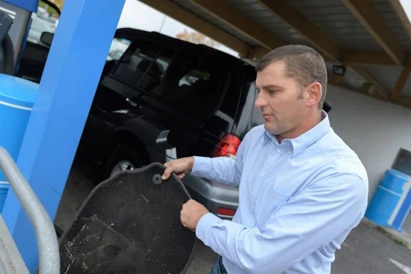 Man cleaning a car mat — Stock Photo, Image