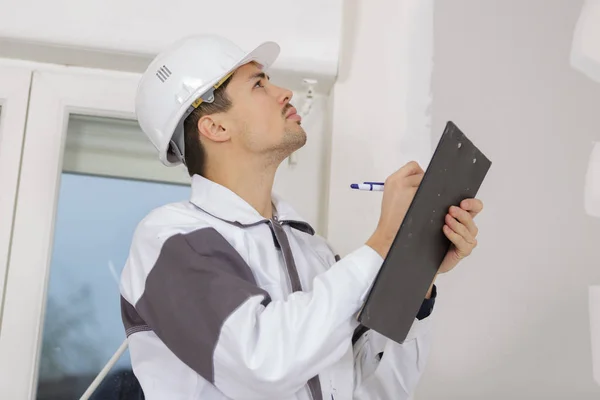 Engenheiro bonito usando prancheta dentro de casa — Fotografia de Stock