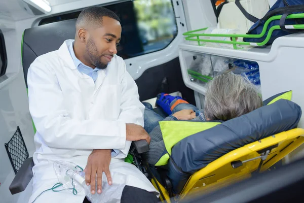 Paramedic sat with patient in back of ambulance — Stock Photo, Image