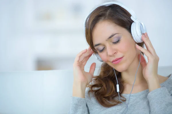 Mujer joven con auriculares escuchando música desde el teléfono inteligente —  Fotos de Stock