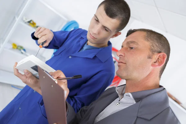 Tutor uitleggen thermostaat aan student — Stockfoto