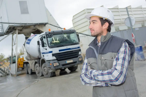 Engenheiro masculino em pé na frente do caminhão no local de construção — Fotografia de Stock