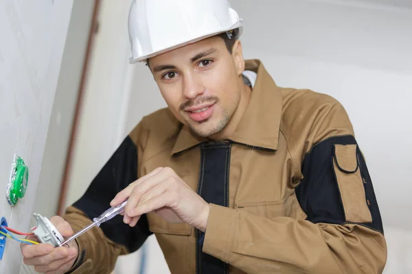 Jeune électricien installant des prises — Photo