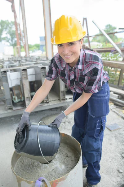 Woman construction builder pouring cement ash — Stock Photo, Image