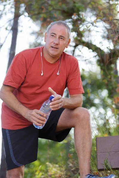 Beau fatigué homme d'âge moyen dans sportsa bouteille d'eau — Photo