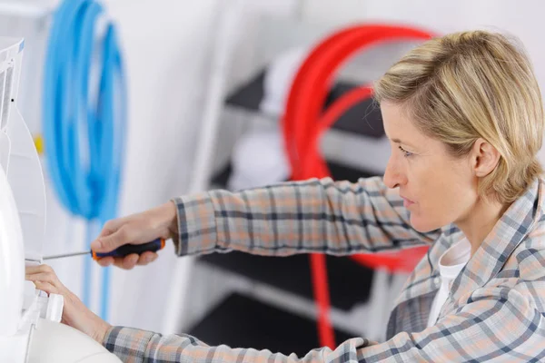 Woman fixing an appliance — Stock Photo, Image