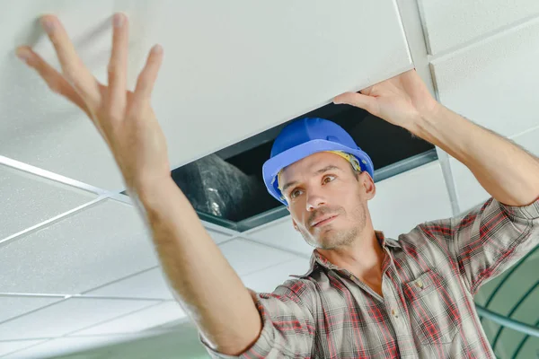 Peering sous un panneau de plafond — Photo