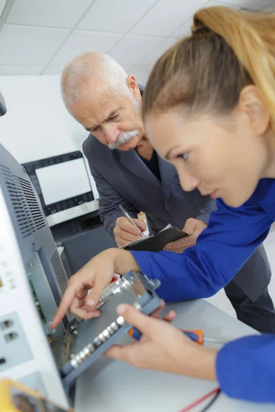 Junge Frau lernt, einen Drucker zu reparieren — Stockfoto